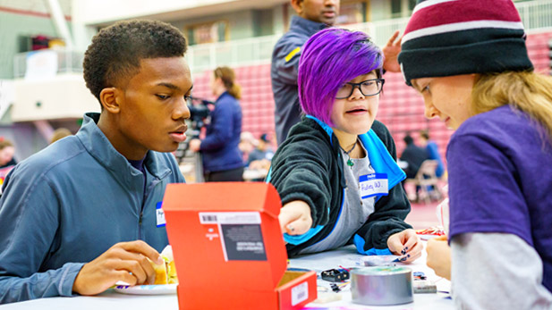 Three students working together at a Spark event