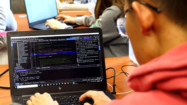 Image shows student working on a laptop computer.