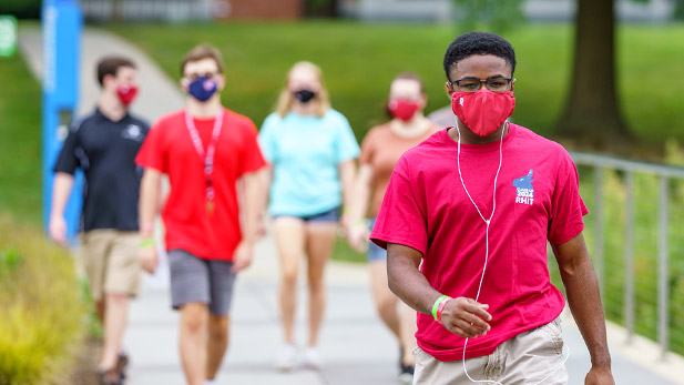 Students wearing COVID-19 prevention masks walking on campus.