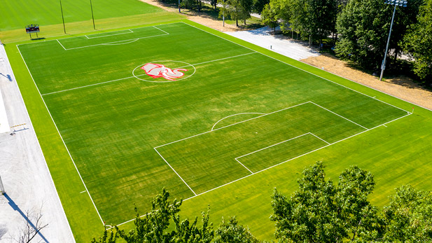 Image shows overhead view of new synthetic soccer field, including Rose-Hulman athletic "Rosy" logo at midfield.