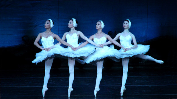 Four ballet dancers in white performing Swan Lake
