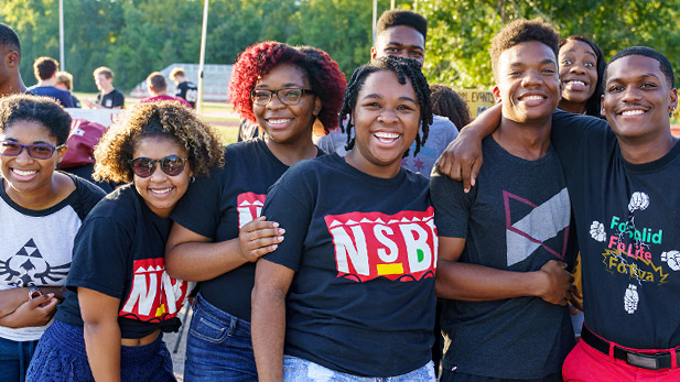 Image shows a group of NSBE members smiling together outside on campus.