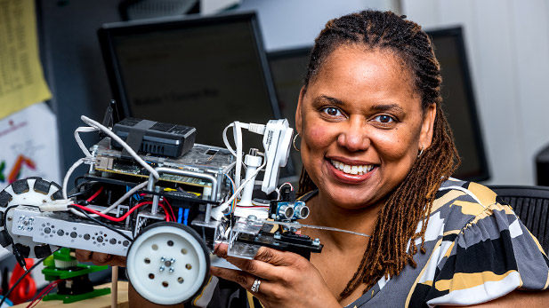 Carlotta Berry holds up a robot.