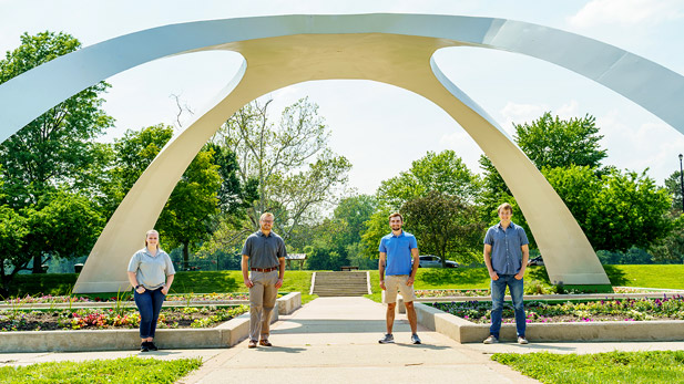 Image shows students posing under fountain at Fairbanks Park.