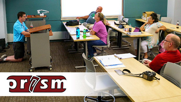 Image shows teachers in a classroom listening to a presentation.