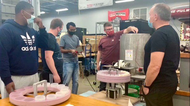 Four students talking with company owner inside a Rose-Hulman innovation space.