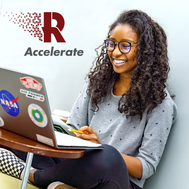 Image shows female student smiling and working on her Rose-Hulman laptop.