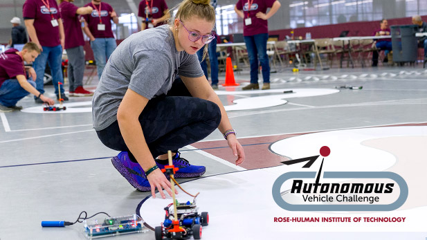 A student places her autonomous vehicle on the track at the Rose-Hulman event.
