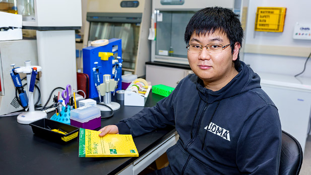 Ferguson Zhang sitting at a desk with books.