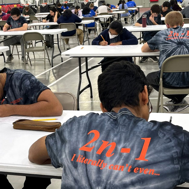 Students work on math problems at a table.