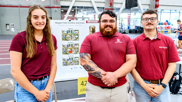 Allie Fults, Tyler Pessler, and Carter James display their project and poster during the Rose Show.