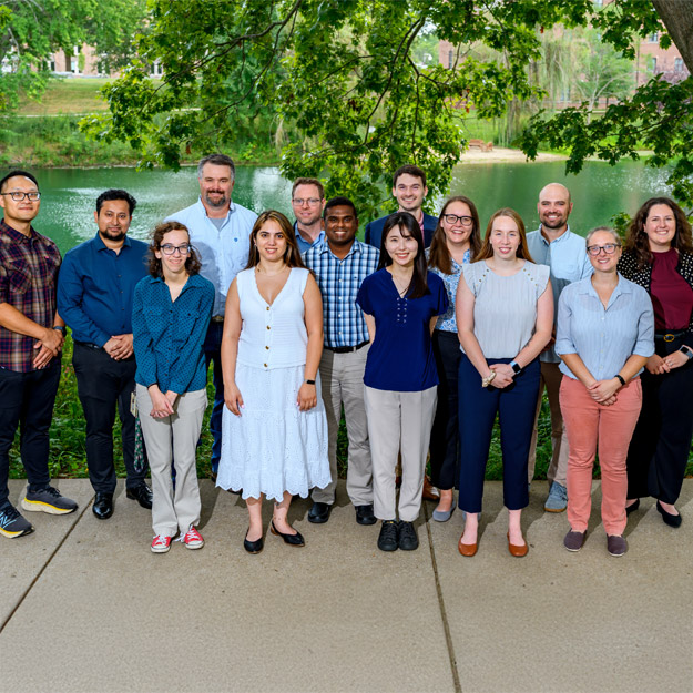 New faculty standing by Speed Lake in summer.