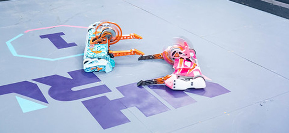 Two robots clash with whirring weapons.
