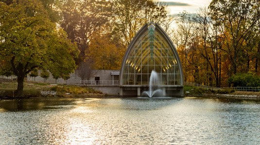 Exterior view of White Chapel at sunset with Speed Lake in the foreground.