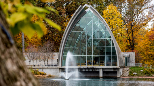 : Exterior view of White Chapel with Speed Lake in foreground and fall foliage.
