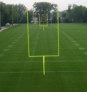 Image shows the bright yellowish-green goal posts on the Intramural Football fields. The elevated view is from behind the end zone. 