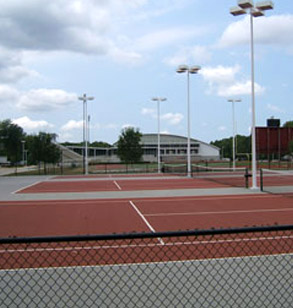 Image shows the Joy Hulbert tennis courts at Rose-Hulman on a partly cloudy day. The Sports and Recreation Center is visible in the distance.