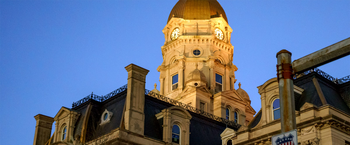 Image shows the illuminated Vigo County Courthouse with a rich evening blue sky in the background. 