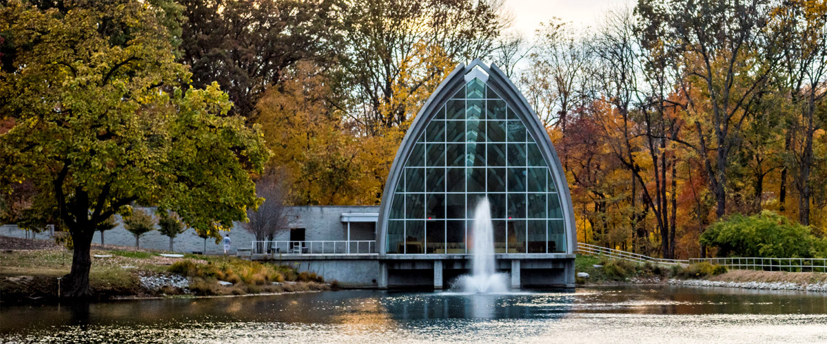 Exterior view of White Chapel with Speed Lake in foreground and fall foliage.